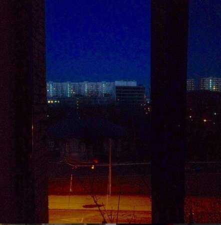 Anya's view in Moscowâ€‹ looking out from a window to the street, sky, and buildings in the distance