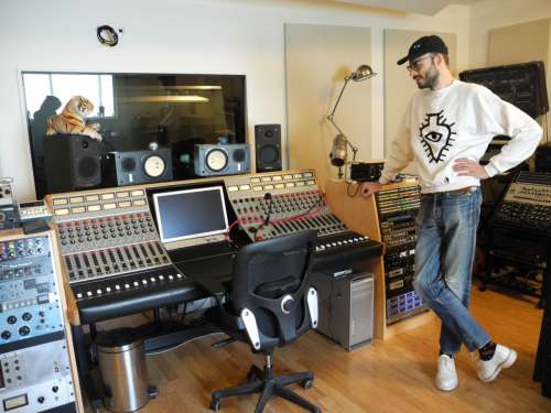 Joakim standing over a soundboard in his studio, Crowd Spacer, in Brooklyn, NY