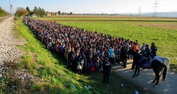 Police forces stop asylum seekers on their way to a refugee center after crossing the Croatian-Slovenian border near Rigonce on October 24, 2015.
